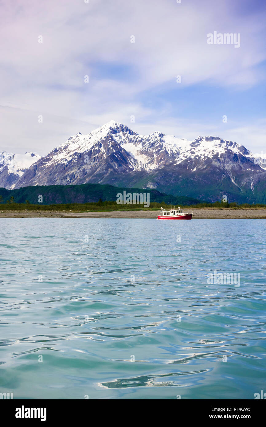 Un bateau à moteur motor cruising yacht ancré dans une belle baie sauvage Cove près de montagnes couvertes de neige, Glacier Bay National Park, Alaska, USA Banque D'Images