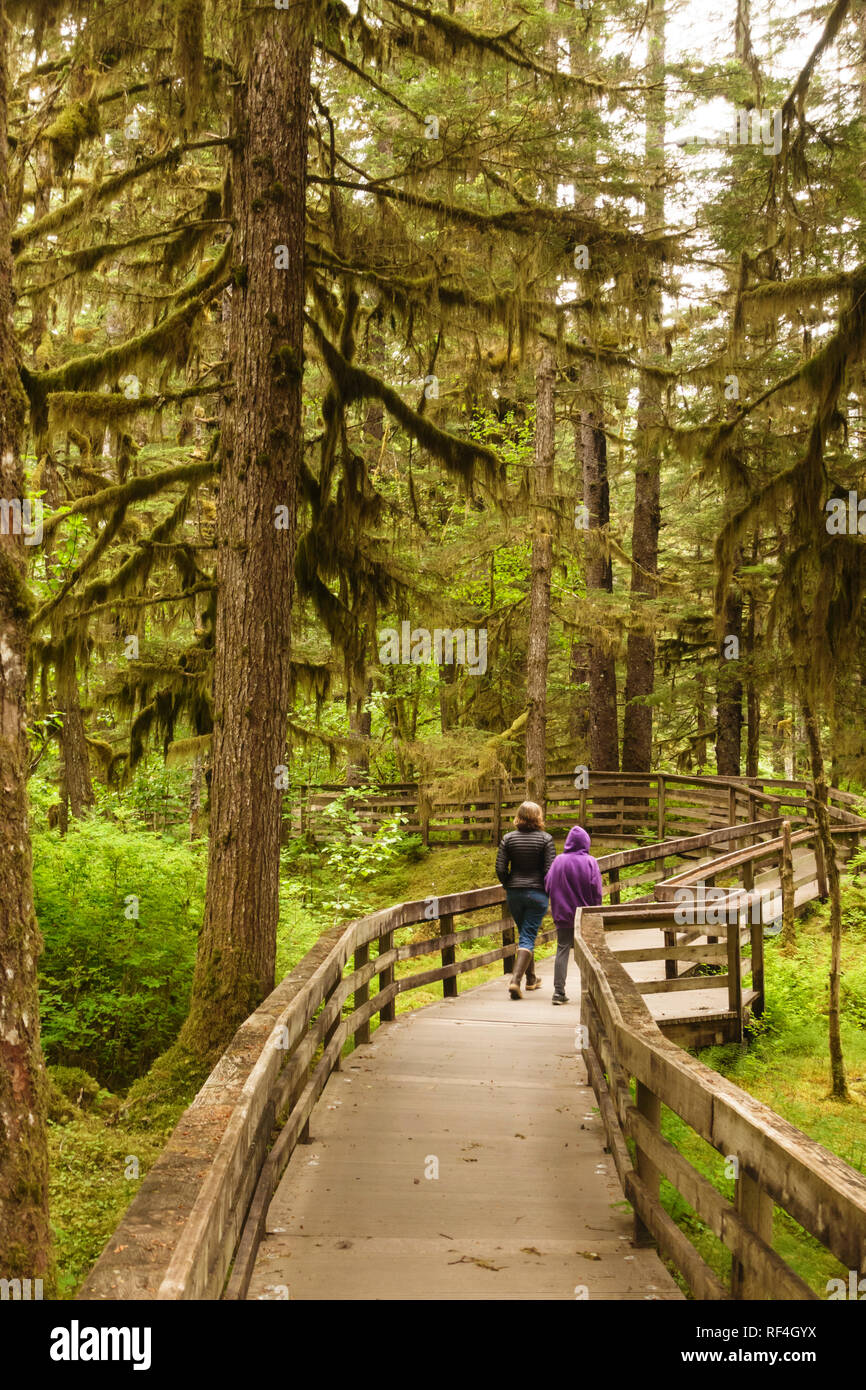 Randonnée à pied les gens profiter de la nature sur un sentier de la promenade à travers la forêt côtière forêt tropicale à Bartlett Cove, Glacier Bay National Park, Alaska Banque D'Images
