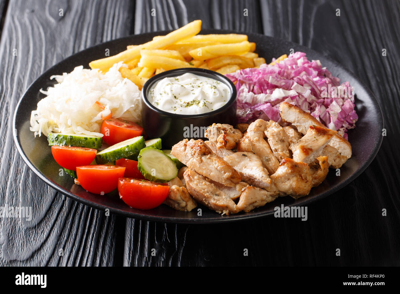 Döner Kebab sur une assiette de frites, salade et sauce gros plan sur une  table de bois horizontal Photo Stock - Alamy