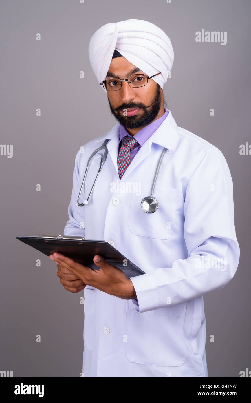 Portrait du jeune Indien Sikh doctor holding clipboard Banque D'Images
