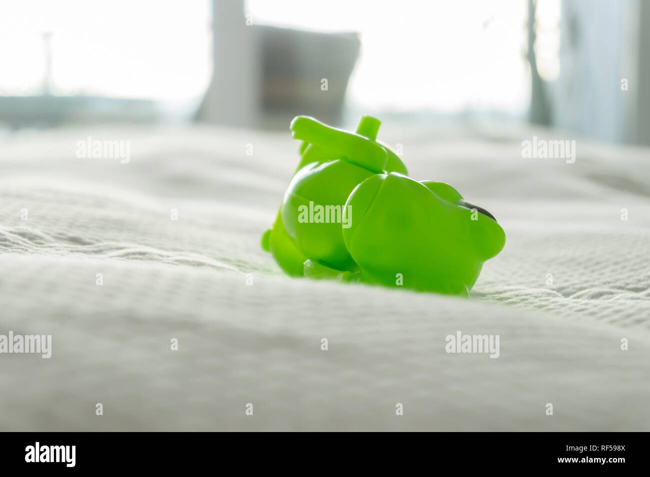Libre de jouet dinosaure sur un lit avec des draps blancs et des draps blancs, dépeignant la vie de parent et ludique accueil avec les enfants. Banque D'Images