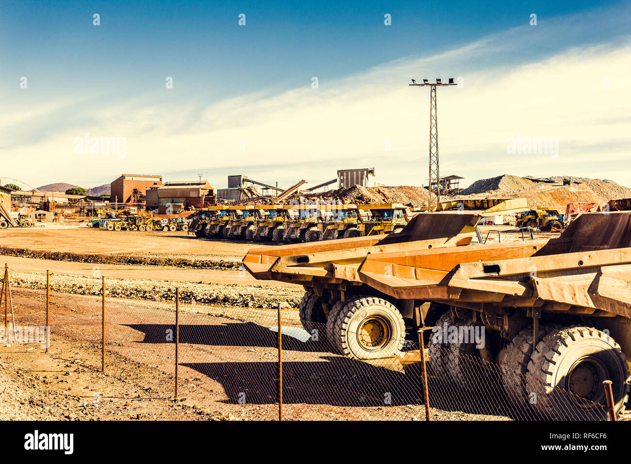 Gros camions tombereaux dans la mine à ciel ouvert de Riotinto, file en attendant leur prochaine affectation avec l'ancien bâtiment de l'exploitation minière et de ciel bleu dans le backgrou Banque D'Images