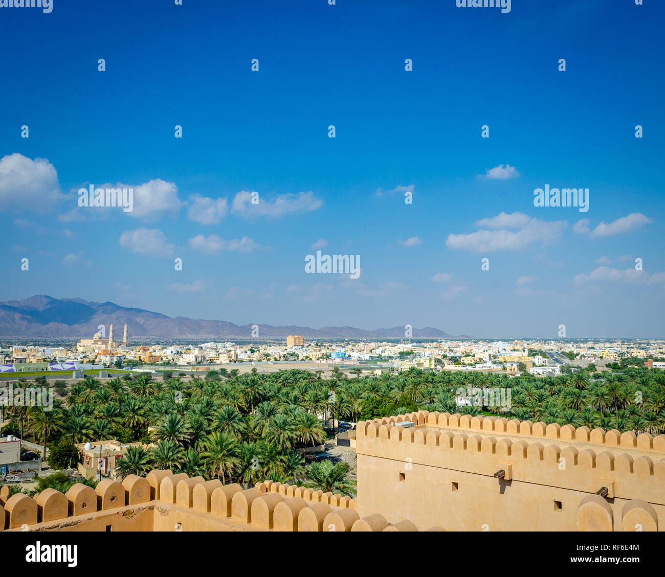 Oasis dans le désert, Barka canton et les montagnes au loin vue de la terrasse du Fort de Nakhal, Muscat, Oman. Banque D'Images
