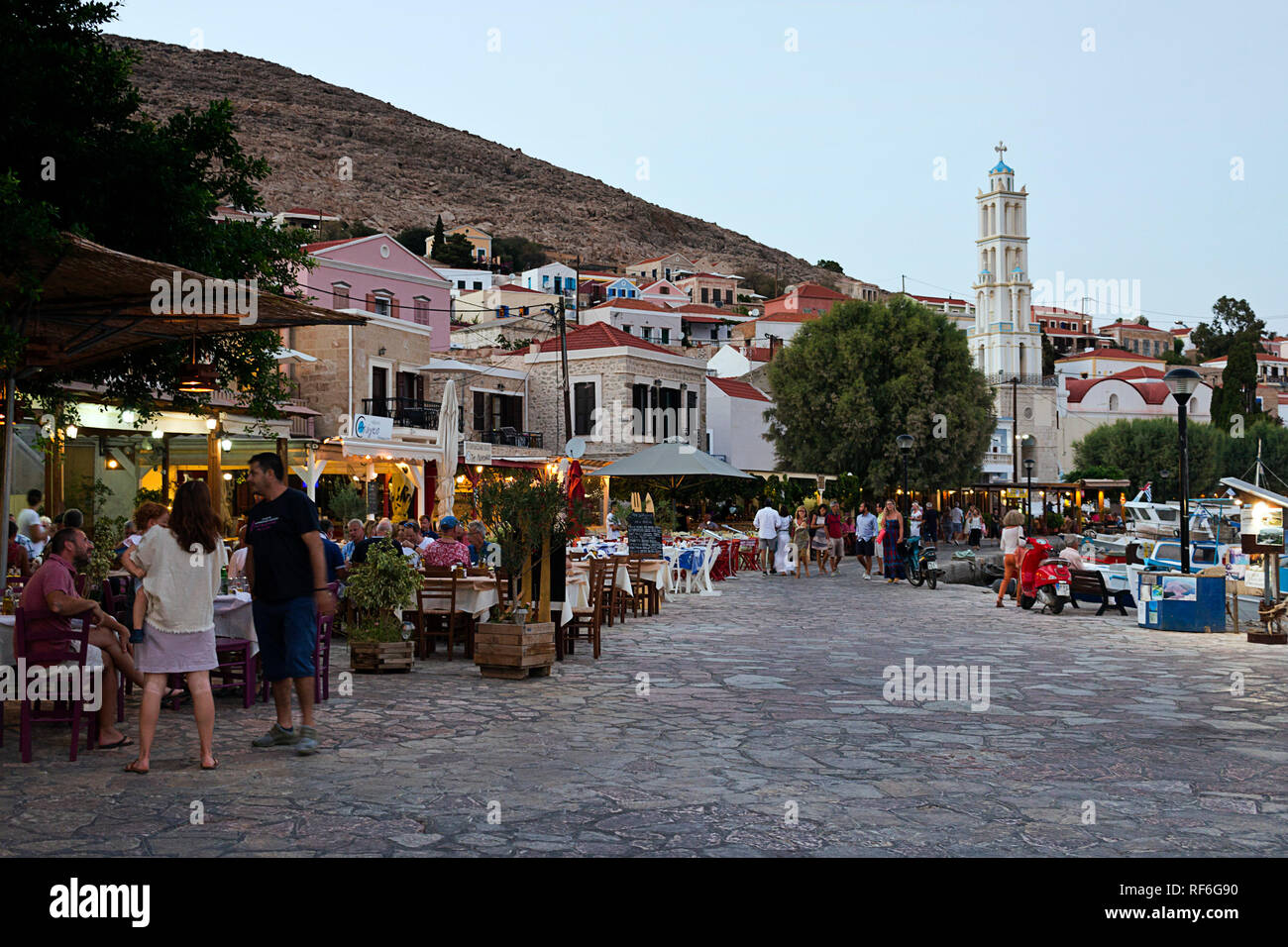 L'île de Halki, Grèce - 27 août 2018. Les gens marchent sur la promenade du front de mer, plein de restaurants tavernes grecques traditionnelles. Est la plus petite de Halki Banque D'Images
