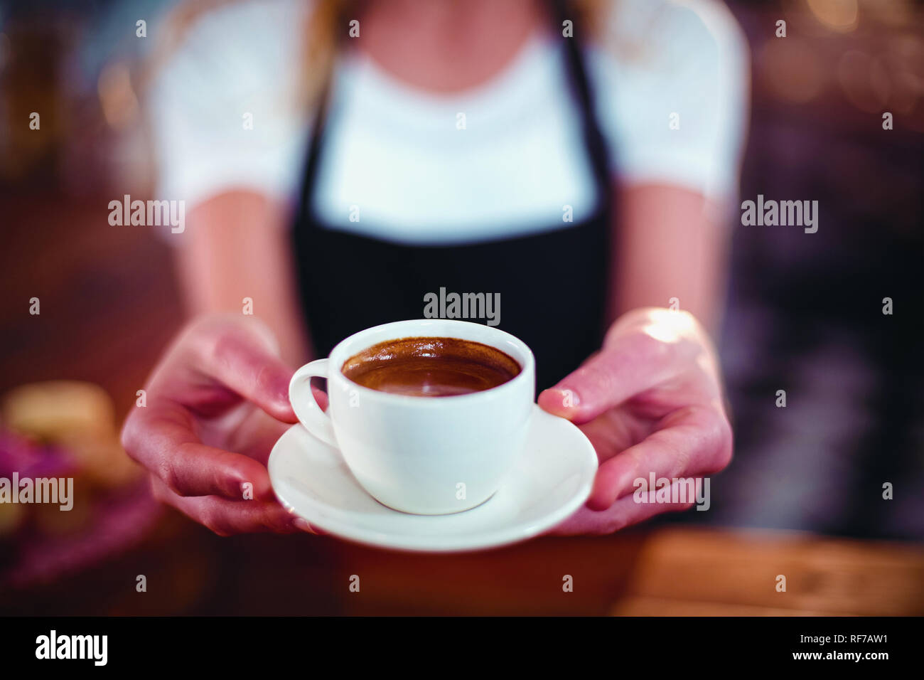 Serveuse offrant une tasse de café Banque D'Images