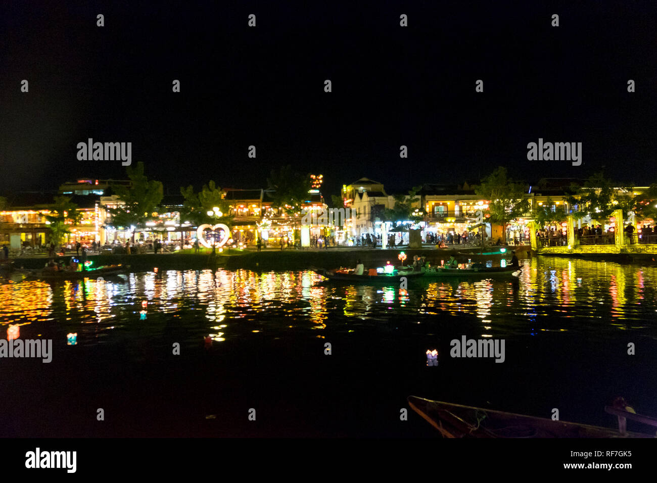 La dérive des bateaux le long de la belle rivière Thu Bon comme la nuit est éclairée par des lanternes à Hoi An, Vietnam. Banque D'Images