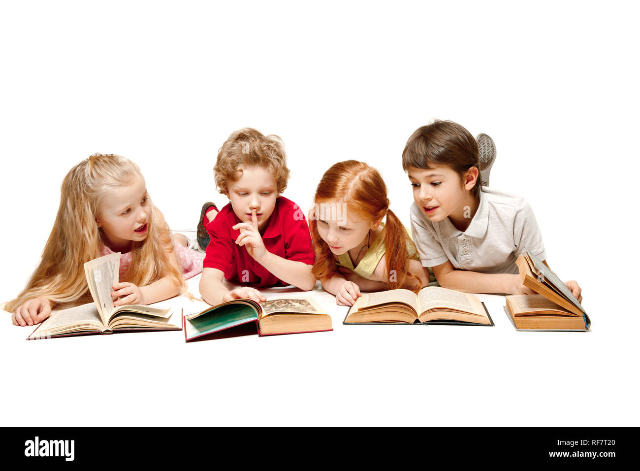 Les jeunes filles et garçon fixant avec des livres au studio, sourire, rire, isolé sur blanc. Jour de réserve, l'éducation, l'école, l'enfant, des connaissances, de l'enfance, l'amitié, de l'étude et concept Banque D'Images