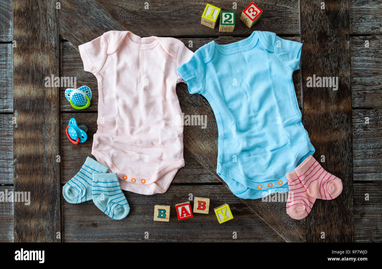 L'habillement de bébé en rose et bleu sur fond de bois rustique Banque D'Images