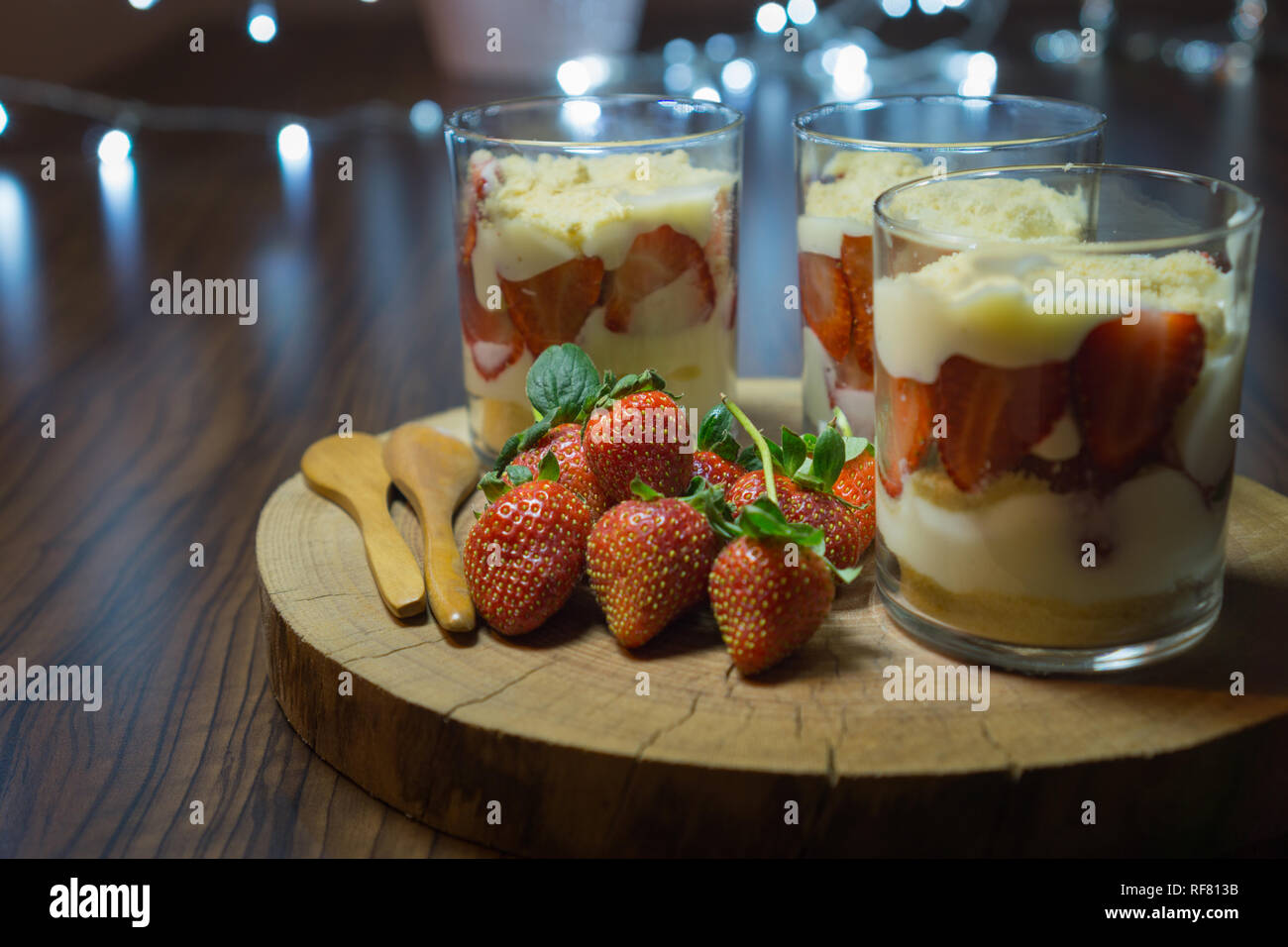 Magnolia en dessert tasses. Servi sur plaque de bois avec strawberriesand cuillères en bois. Fermer Vue de face. Banque D'Images Magnolia en dessert tasses. Servi sur plaque de bois avec strawberriesand cuillères en bois. Fermer Vue de face. Banque D'Images