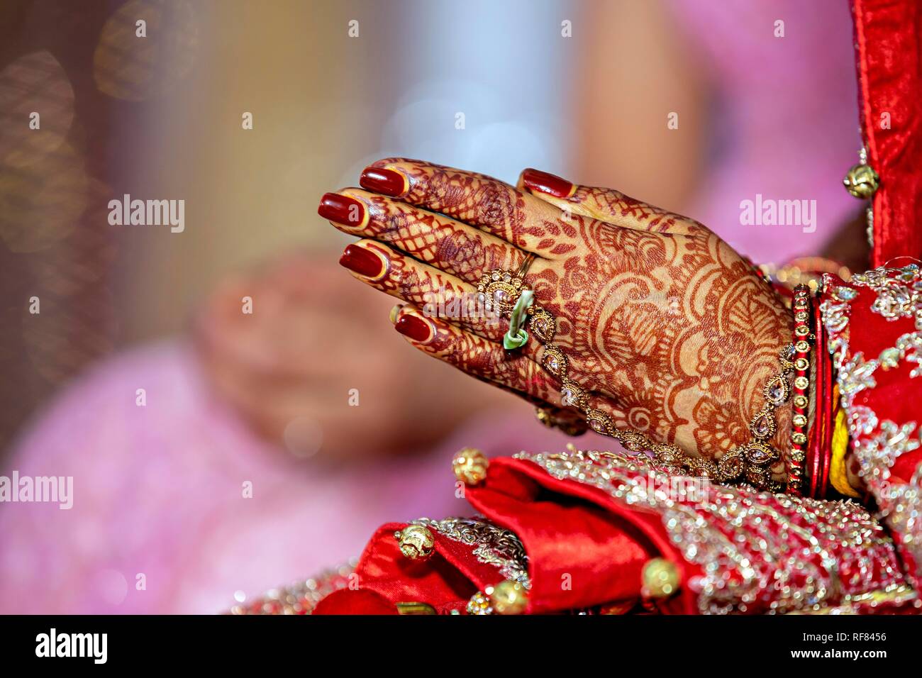 Bijoux de mariée traditionnel et décoration au henné sur les mains de la mariée durant une cérémonie religieuse à un mariage hindou Banque D'Images