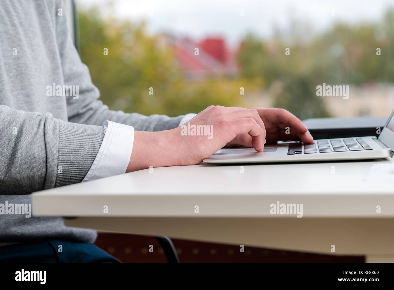 Man hands typing on laptop keyboard au bureau. Les hommes et les gens d'affaires concept. Soft focus sur table en bois blanc moderne. Banque D'Images