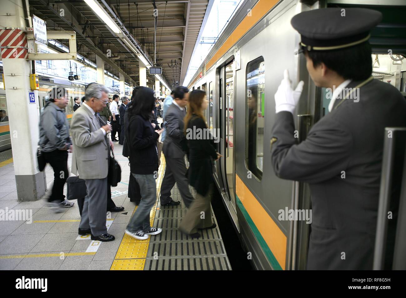 Chef de train à plate-forme pour JR-Line trains locaux, la gare de Tokyo, Tokyo, Japon, Asie Banque D'Images