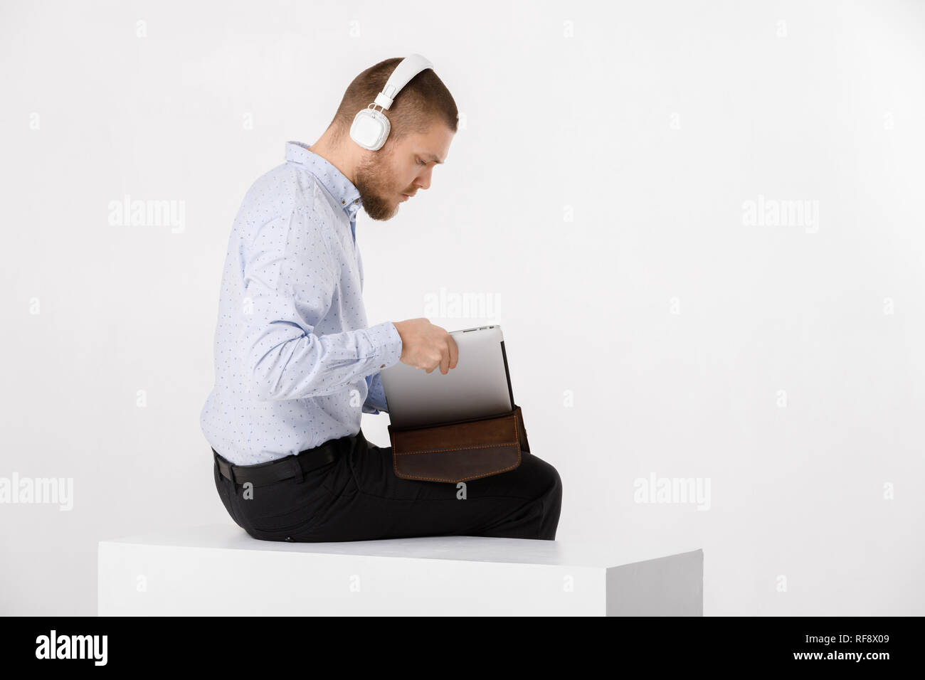 Businessman in headphones met dans le couvercle pour ordinateur portable Banque D'Images