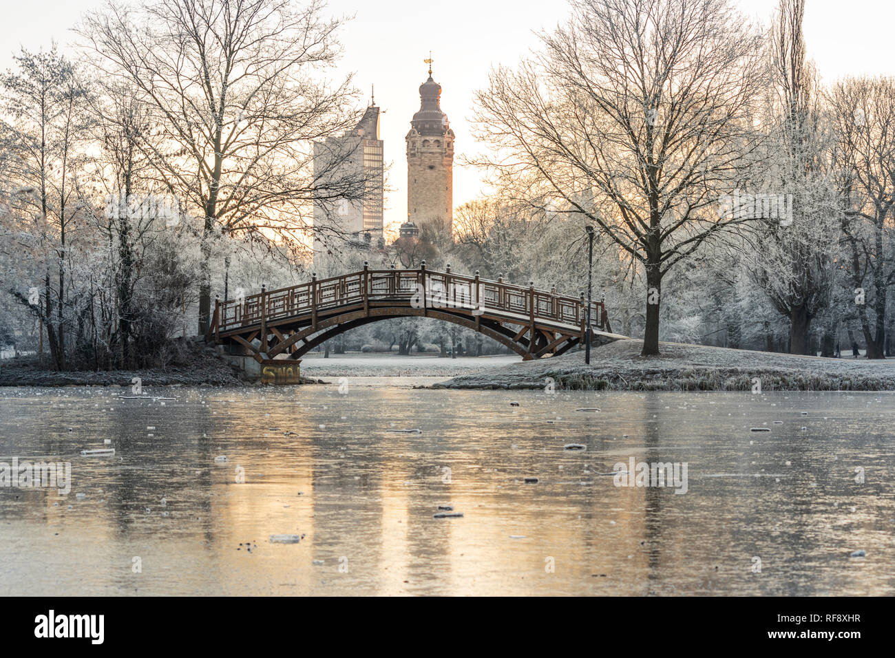 Leipzig im Frost, Brücke im Johannapark, vereister Teich mit Blick zum Neuen und réflexion Rathaus und zum City-Hochhaus Banque D'Images