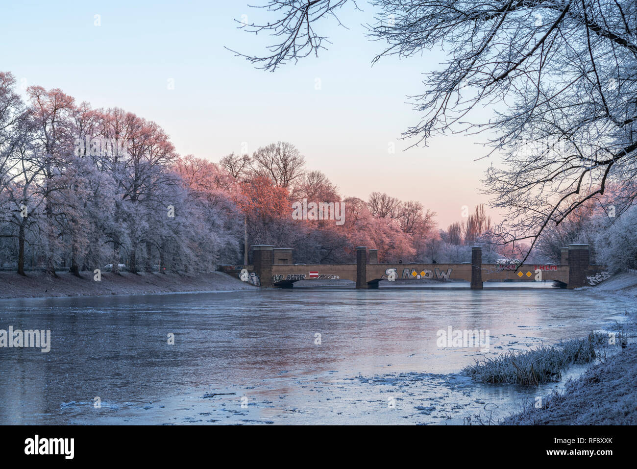 Leipzig im Frost, Brücke über die Weiße Elster vereiste erstes und rotes Licht auf den Bäumen vereisten Am Ufer Banque D'Images
