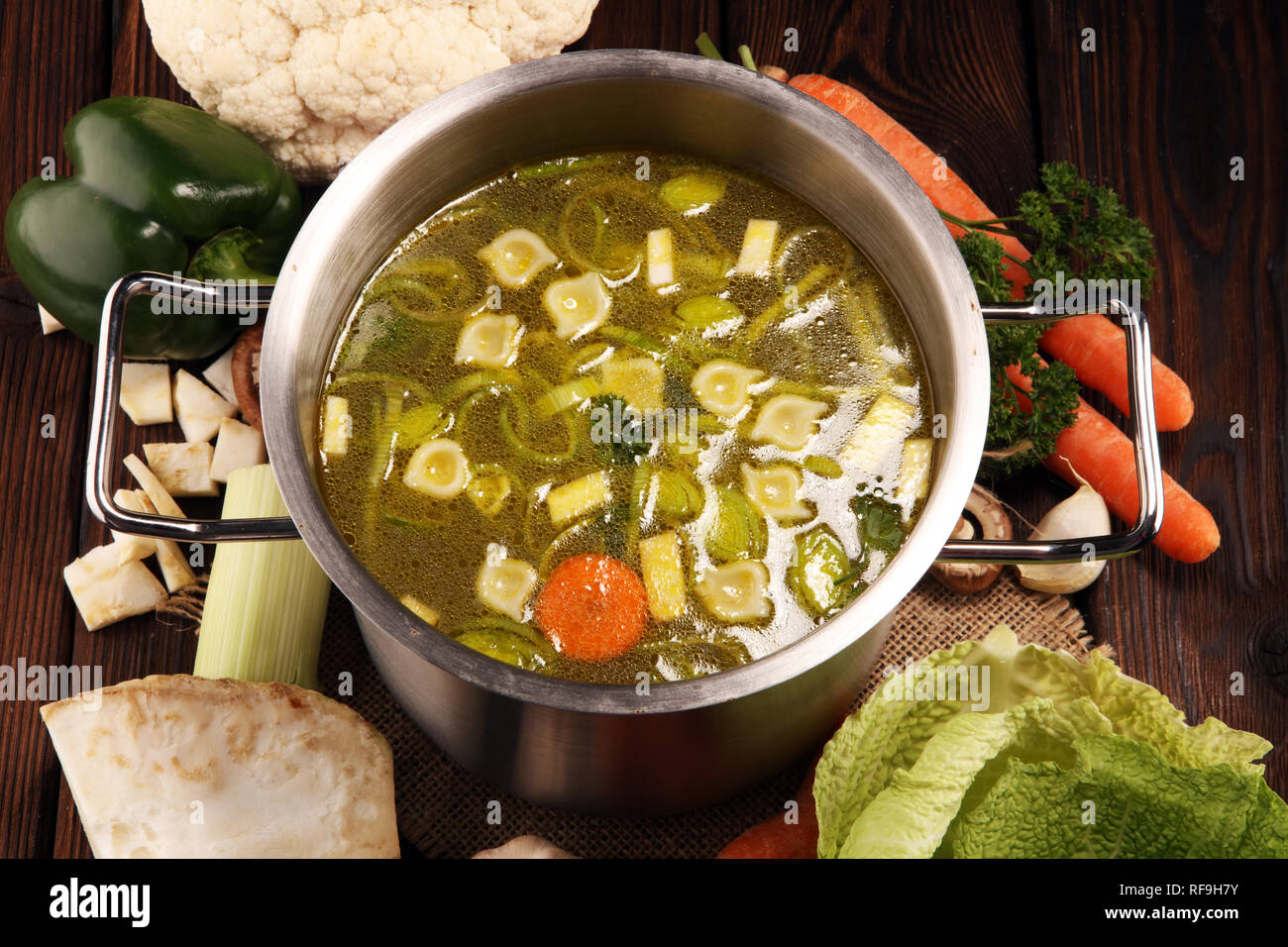 Bouillon avec carottes, oignons divers légumes frais dans un pot - frais colorés clear spring soupe. Cuisine végétarienne paysage rural bouillon Banque D'Images