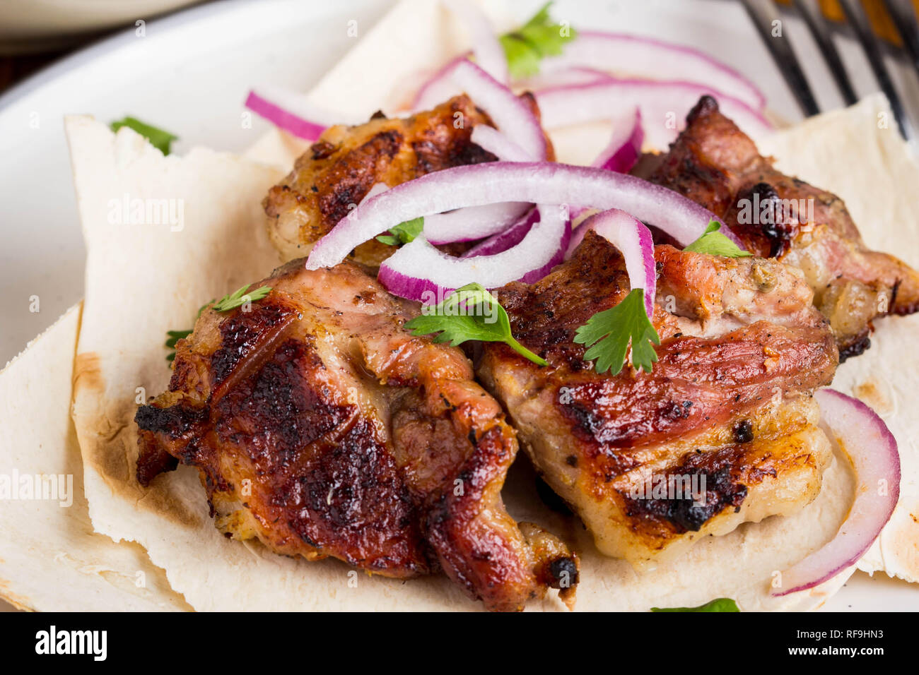 Kebab, morceaux de viande, boeuf, porc sur pita fine à l'oignon et salade Banque D'Images