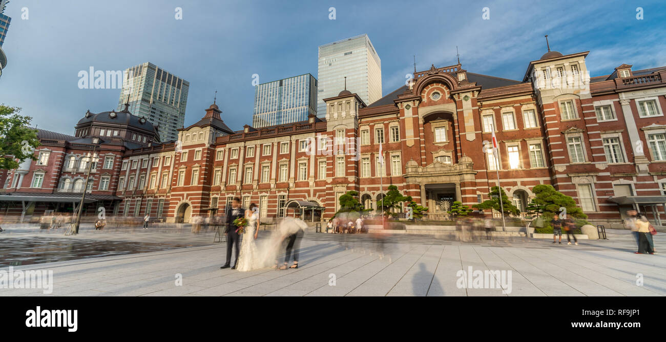 Vue panoramique de Motion Blurred personnes posant avec des robes et des gens qui marchent en face de la gare de Tokyo Banque D'Images