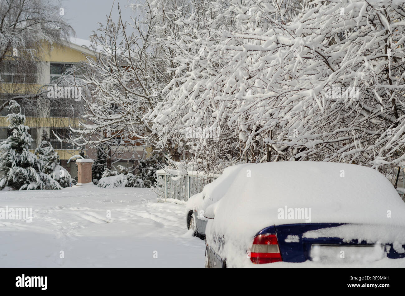 Fragment d'une voiture sale sous une couche de neige pendant des chutes de neige importantes, de la voiture est recouverte de neige, Banque D'Images