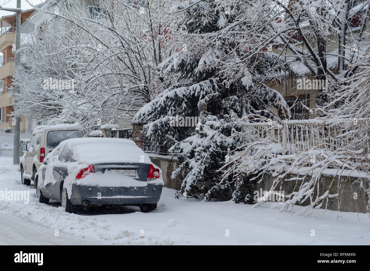 Fragment d'une voiture sale sous une couche de neige pendant les fortes chutes de neige, les voitures sont couvertes de neige, Banque D'Images