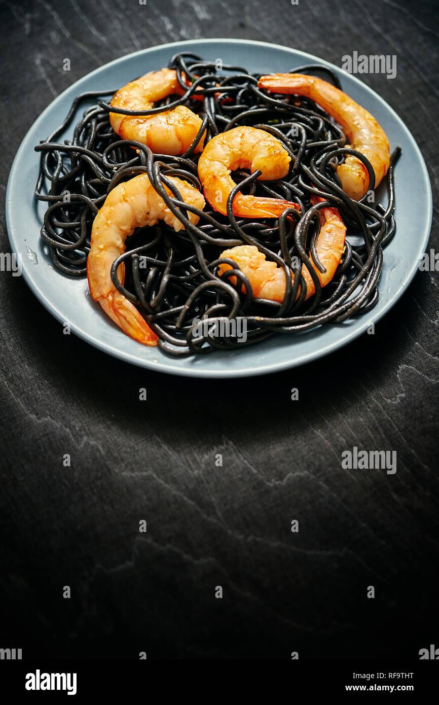 Noir frais, délicieux spaghetti aux crevettes tiger grillées sur une plaque gris sur un tableau noir Banque D'Images