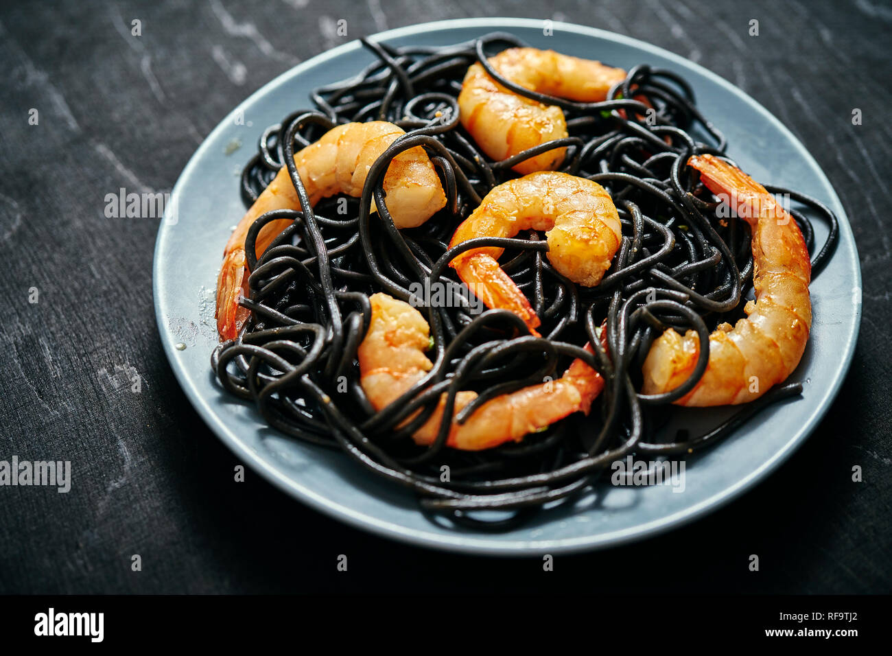 Noir frais, délicieux spaghetti aux crevettes tiger grillées sur une plaque gris sur un tableau noir Banque D'Images
