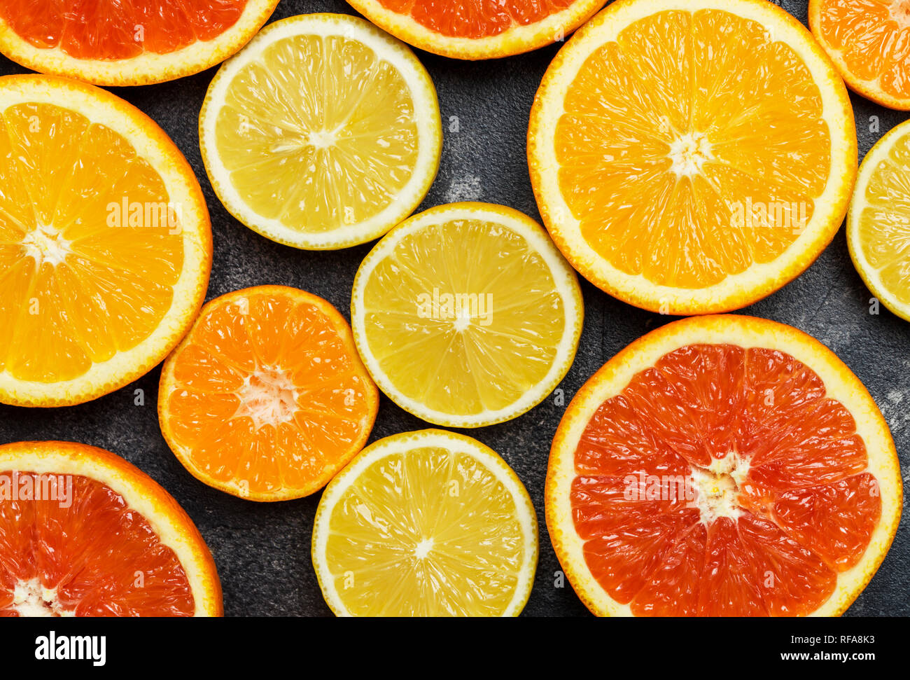 Fond d'agrumes colorés avec orange, pamplemousse, citron, mandarine à fond sombre Banque D'Images Fond d'agrumes colorés avec orange, pamplemousse, citron, mandarine à fond sombre Banque D'Images