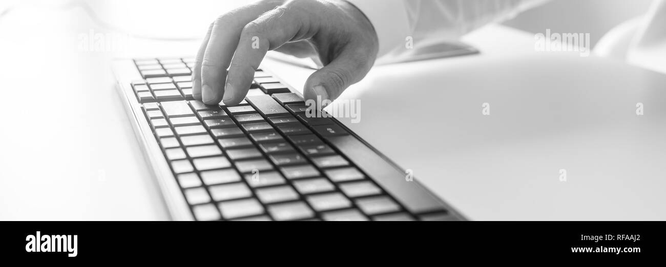 Voir l'échelle de l'image en noir et blanc de l'homme part de la saisie sur clavier d'ordinateur. Banque D'Images
