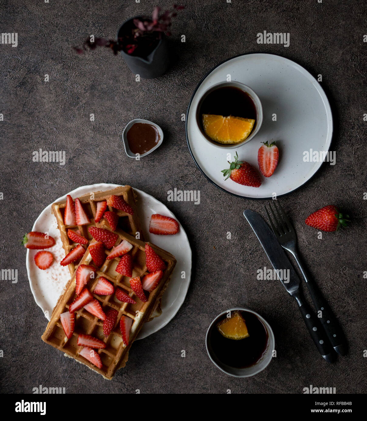 Belgique gaufres savoureuses avec des fraises fraîches à plaque blanche et deux tasse de thé au citron à l'arrière-plan sombre. Concept de style de vie sain pour le menu Banque D'Images