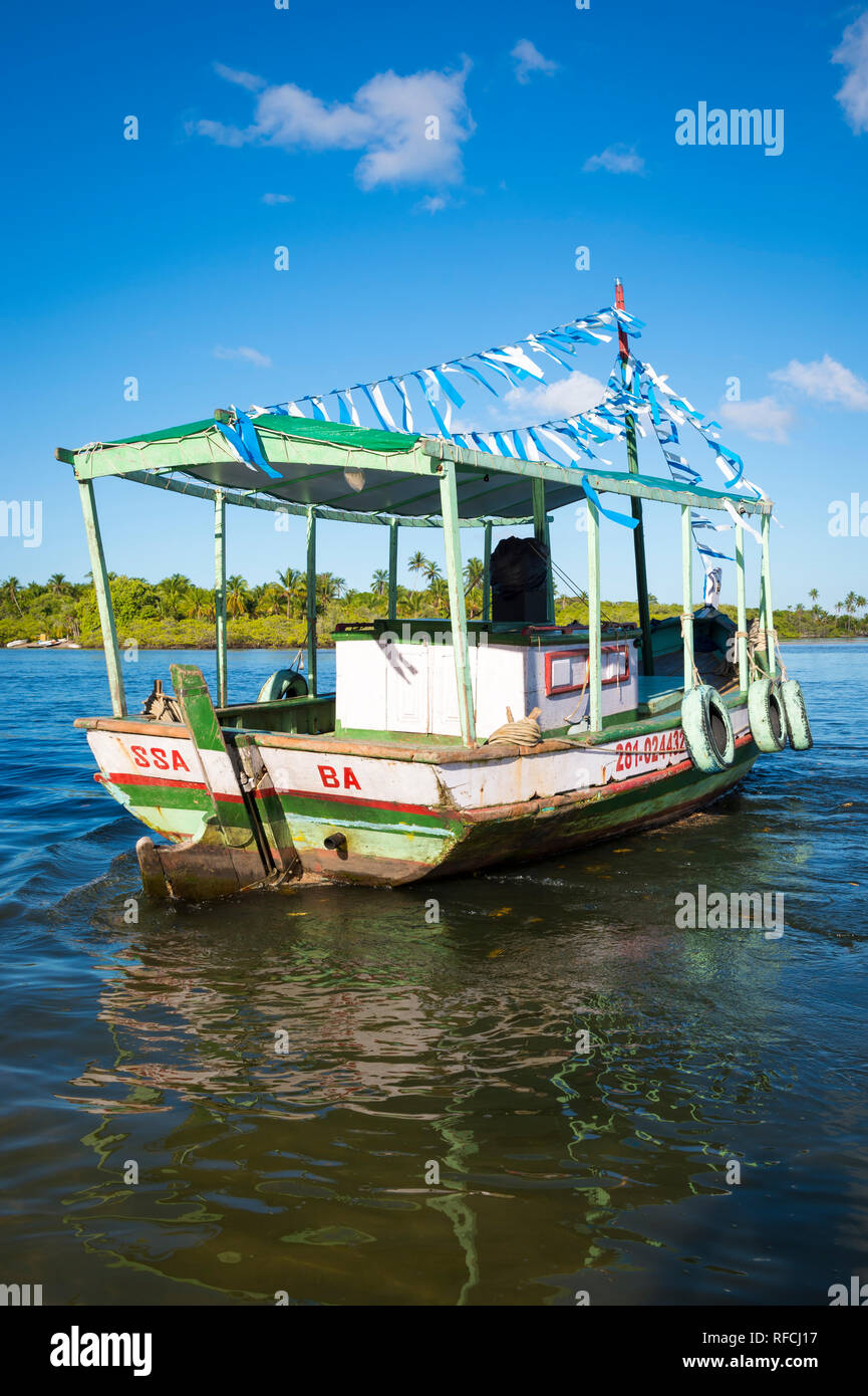 BAHIA, BRÉSIL - Février 2016 : un vieux bateau de pêche brésilien en bois est décoré de banderoles bleu et blanc en hommage à Yemanja. Banque D'Images