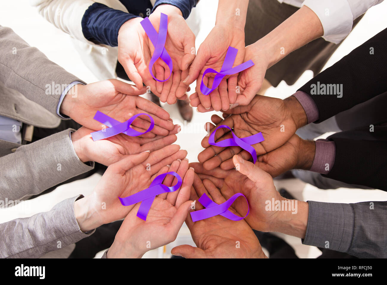 Groupe de Businesspeople Holding Teal Rubans pour appuyer la sensibilisation au cancer du pancréas Banque D'Images