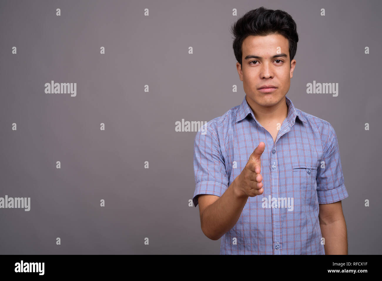 Portrait of young businessman contre l'arrière-plan gris Banque D'Images