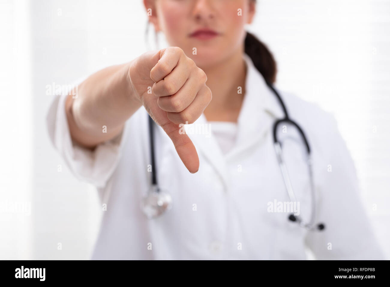 Sad Female Doctor Showing Thumb Down Sign In Clinic Banque D'Images