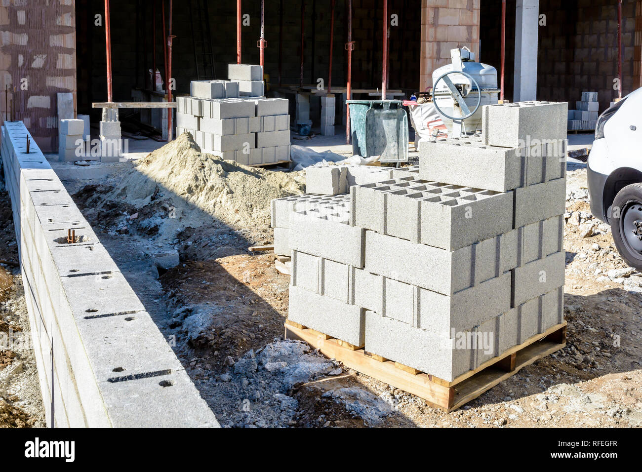 Blocs de béton empilés sur des palettes à l'extérieur devant une maison en construction dans la banlieue de Paris, France. Banque D'Images