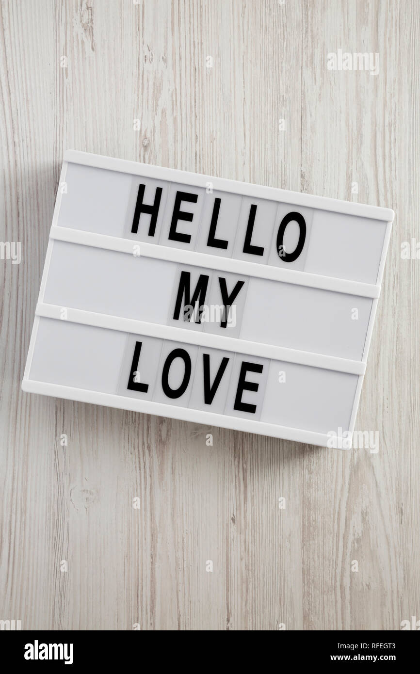 Conseil moderne avec le texte "Bonjour mon amour" sur un fond en bois blanc, vue du dessus. Valentine's Day 14 février. Banque D'Images