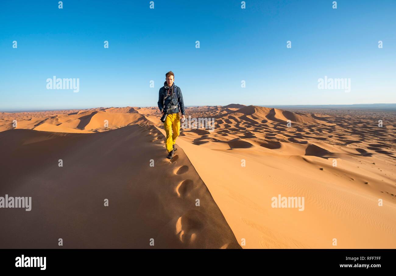 Jeune homme qui courait sur le sable, dunes, Erg Chebbi Merzouga, Sahara, Maroc Banque D'Images