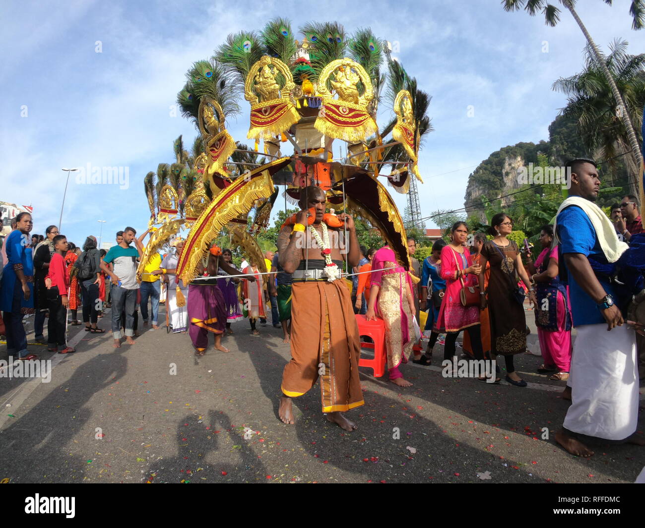 Les dévots man carrying kavadi qu'ils marchèrent vers les grottes de Batu. Banque D'Images