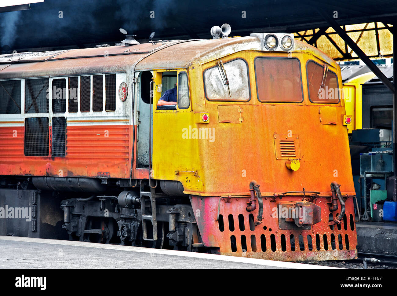 Train Diesel jaune à une plate-forme à la gare de Hualamphong de Bangkok, Thaïlande Banque D'Images