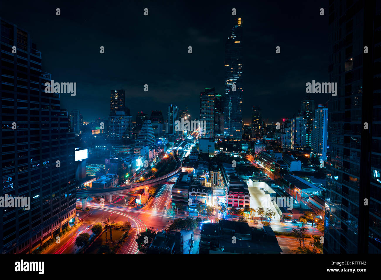 Cityscape du célèbre Maha Nakhon Tower à Bangkok, Thaïlande. Des sentiers de lumière dans les rues de la voitures. Ciel noir derrière la ville de Tours. Banque D'Images