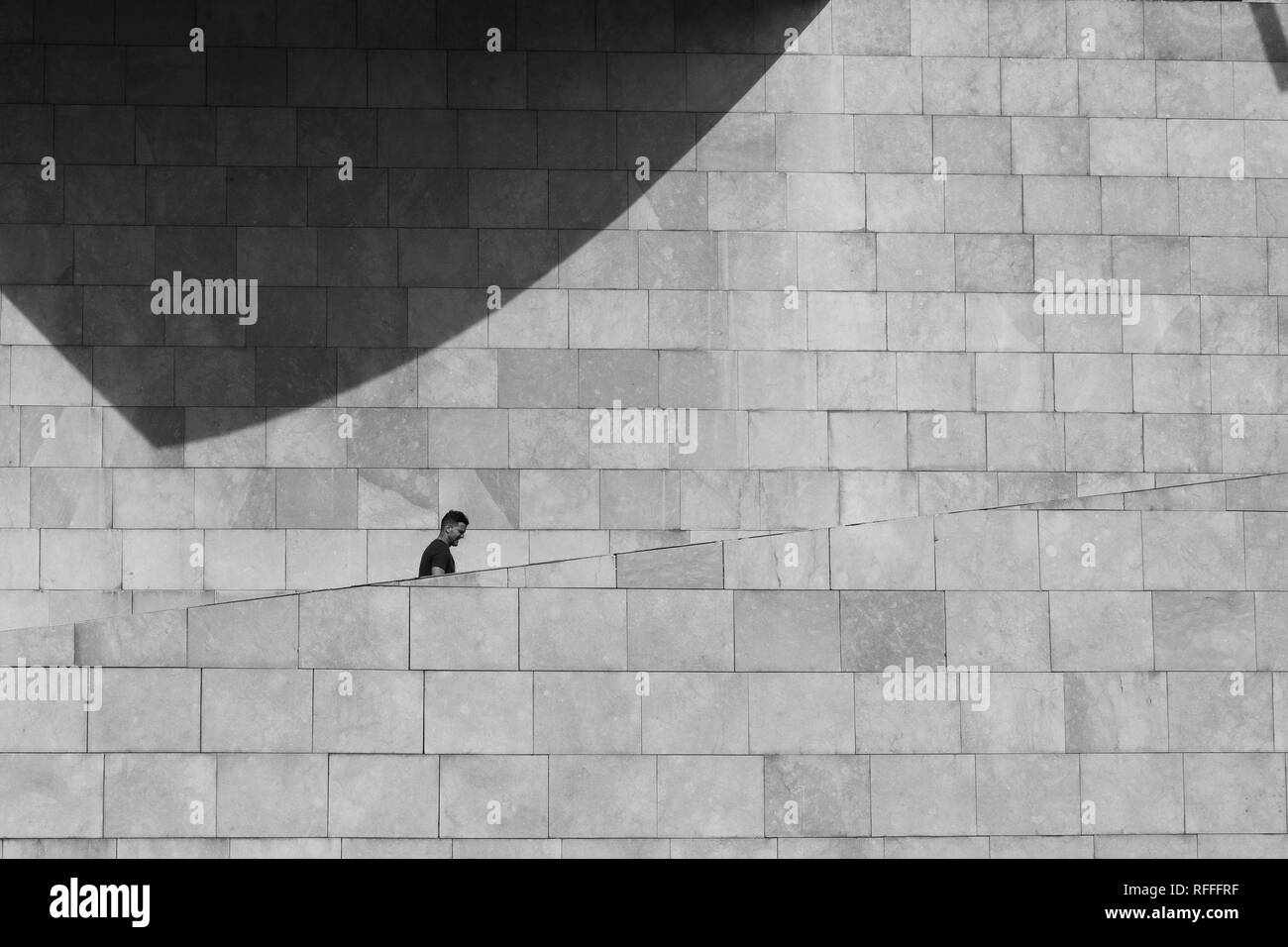Un homme monte les escaliers du musée Guggenheim de Bilbao en noir et blanc, Espagne Banque D'Images