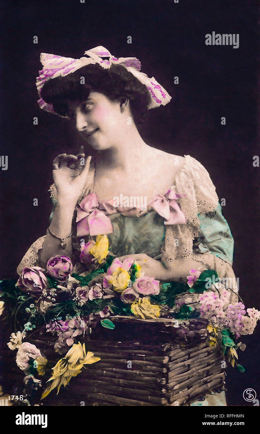 1910s Femme avec fleurs, carte postale vintage. Banque D'Images
