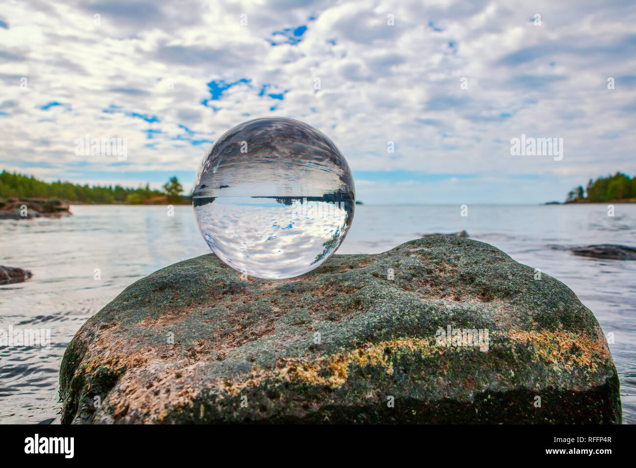 Boule de cristal acrylique sur roche par un lac Banque D'Images