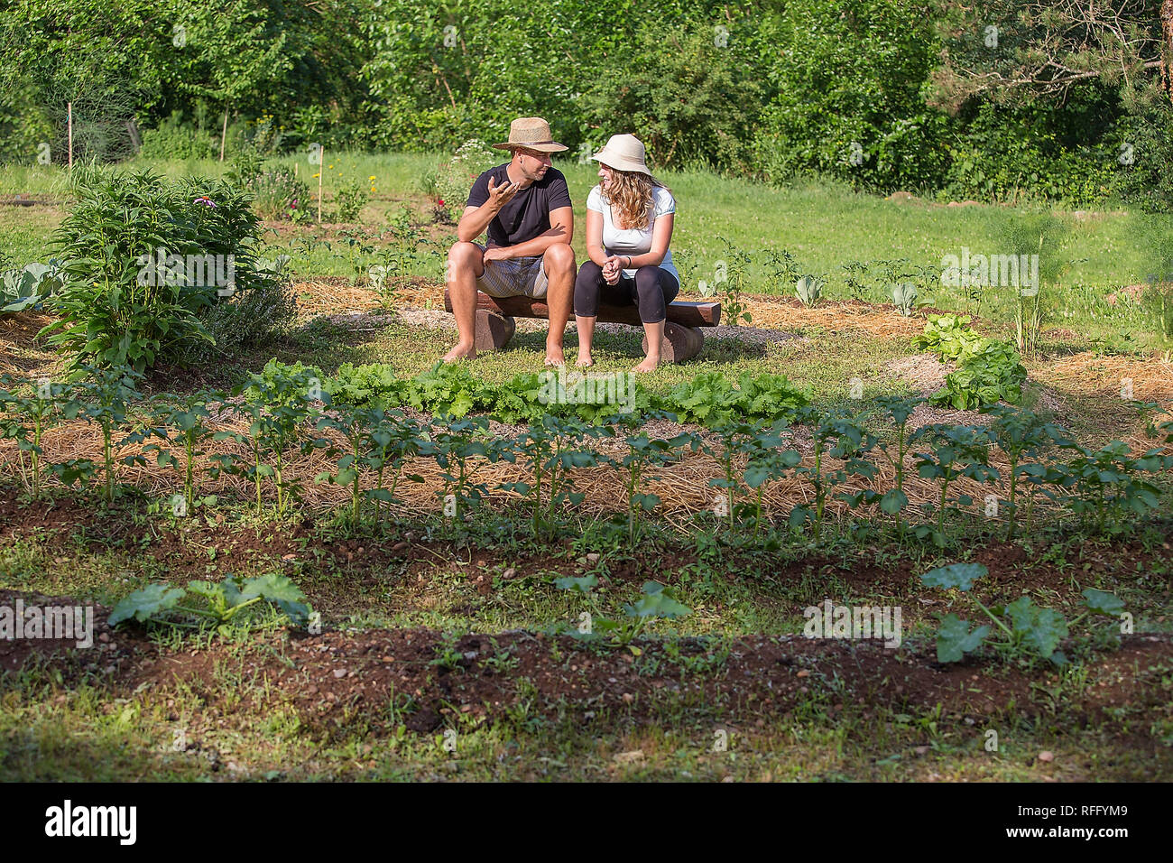 Jeune homme et femme se détendre dans un jardin de légumes Banque D'Images