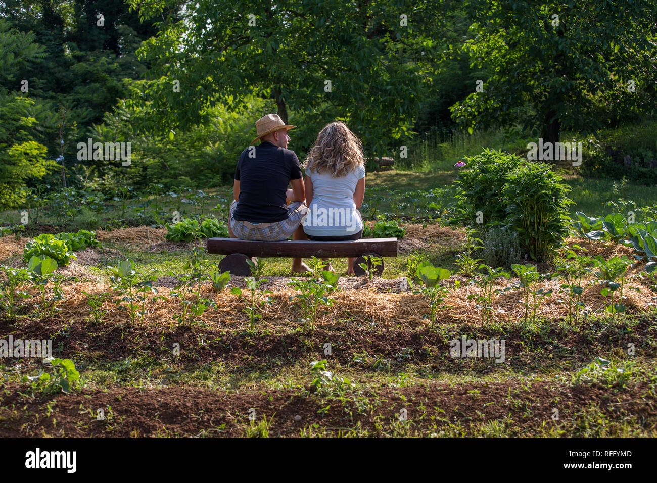 Jeune homme et femme se détendre dans un jardin de légumes Banque D'Images