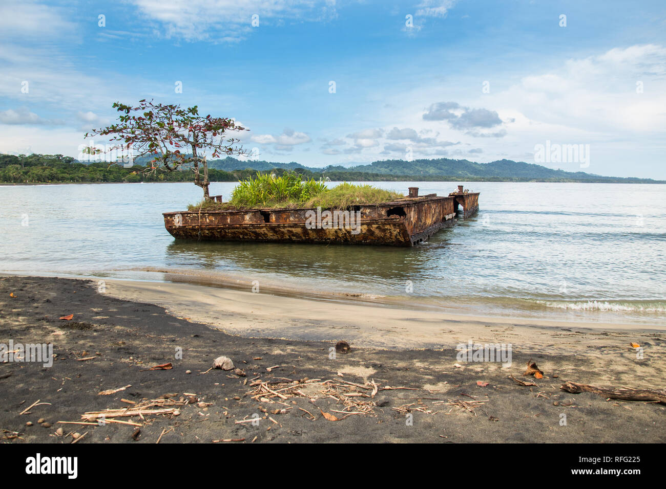 Un paysage coloré photo d'une vieille épave rouillée épave couverte de végétation à la plage de Puerto Viejo, Limón, Costa Rica. Banque D'Images