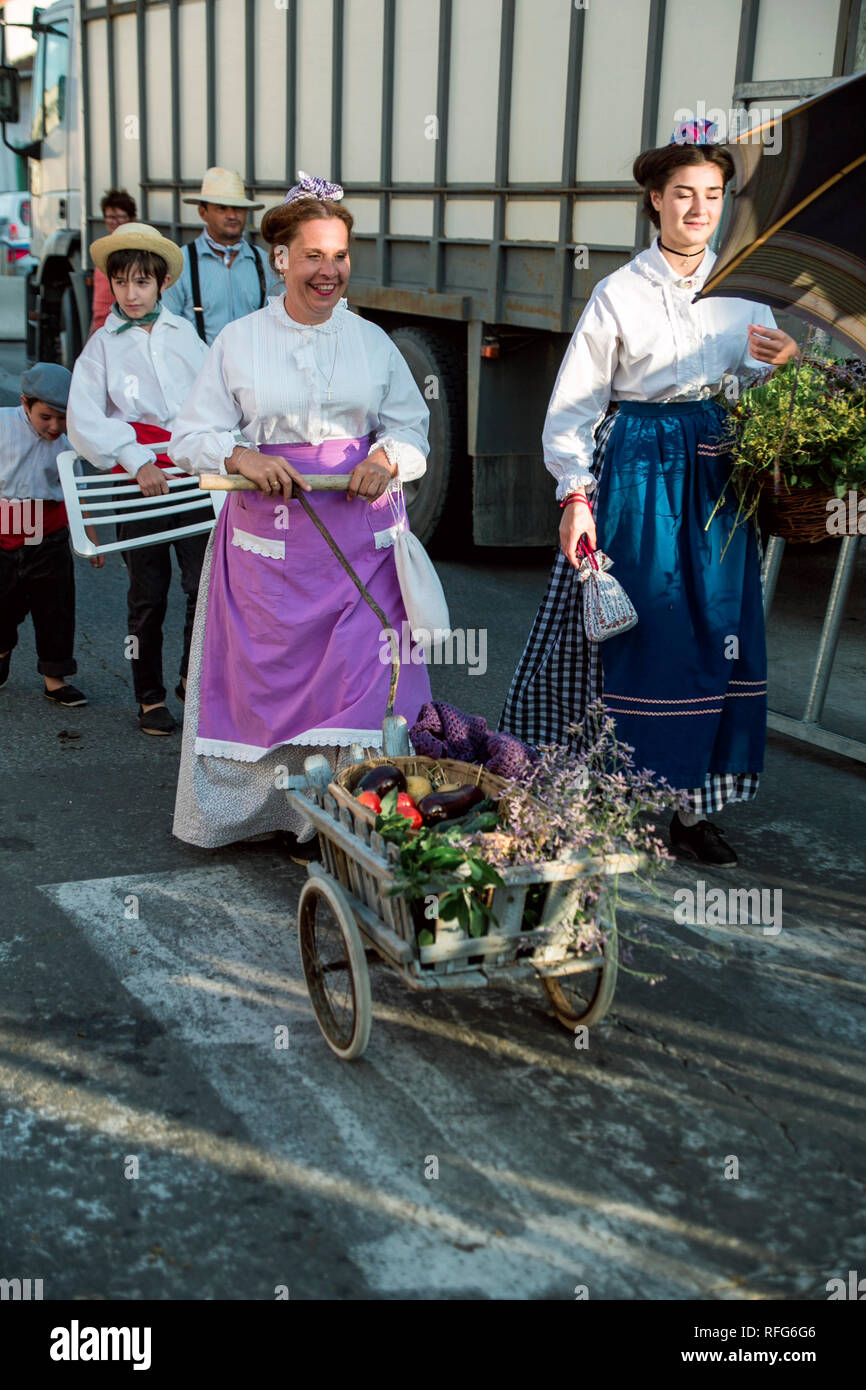 Dame française poussant un panier de produits fermiers dans Old School Défilé des métiers traditionnels à la fête annuelle, Saint Gilles, Gard, France Banque D'Images