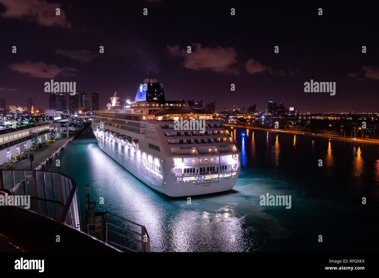 Miami, Floride - 19 novembre 2018 : Norwegian Sky bateau de croisière naviguant dans le Port de Miami juste avant le lever du soleil à l'horizon de centre-ville de Miami Banque D'Images