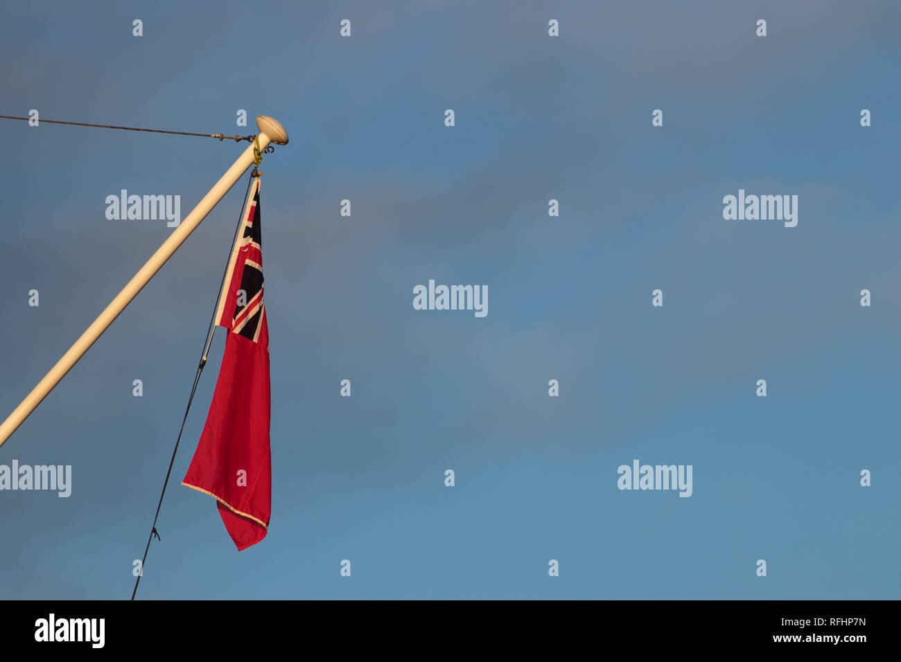 Red Ensign battant sur un mât avec ciel bleu Banque D'Images