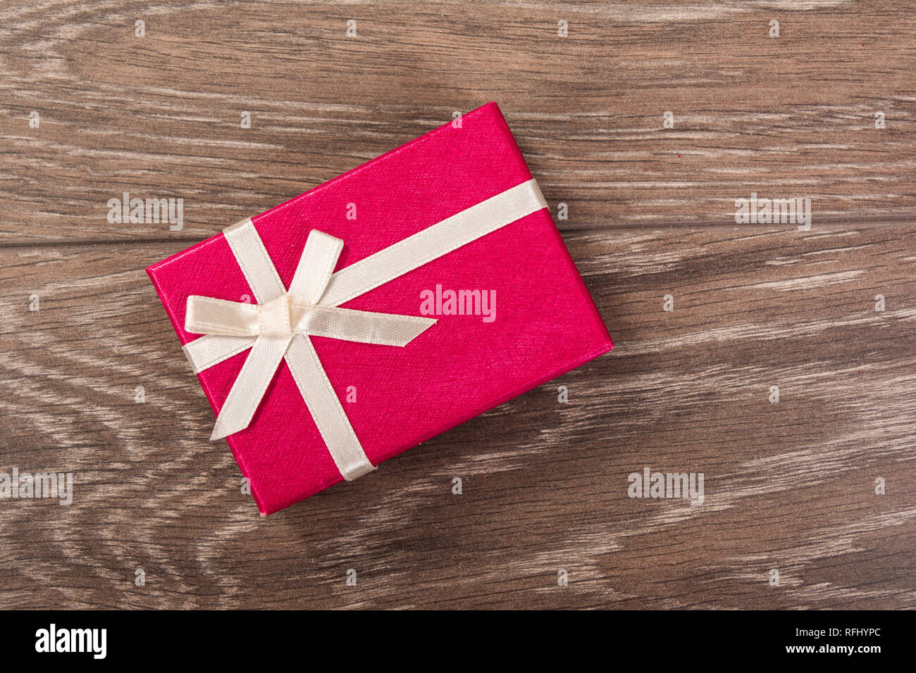 Boîte cadeau rouge avec ruban blanc sur fond de bois Banque D'Images