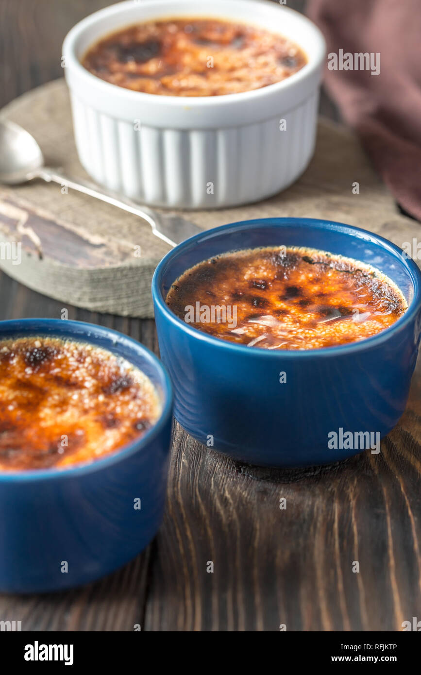 Crème brûlée dans les pots sur la planche de bois Banque D'Images